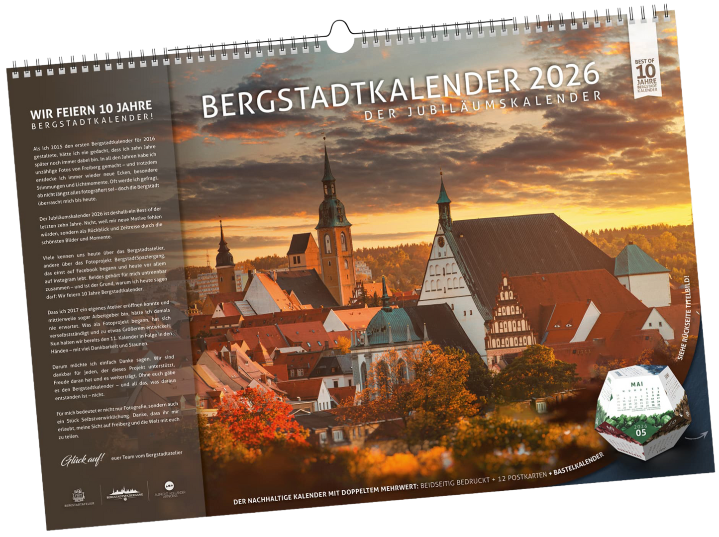 Titelblatt des Bergstadtkalenders 2026 im Format DIN B3 mit Hinweis auf das 10-jährige Jubiläum. Zu sehen ist der Altstadtblick von Freiberg mit Petrikirche und Dom, ergänzt durch den integrierten Bastelkalender in Würfelform.