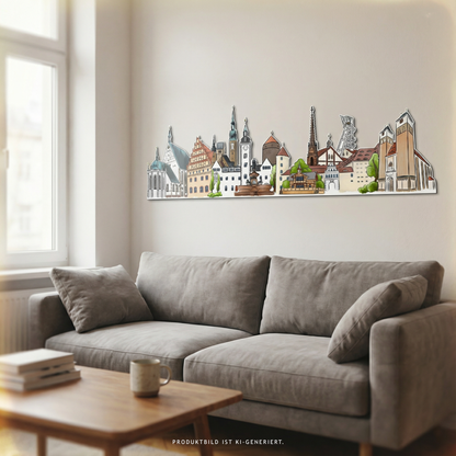Bunte Stadtsilhouette von Freiberg als konturgefräster Alu-Dibond-Wandprint, modern inszeniert über einem Sofa in einem Wohnraum.