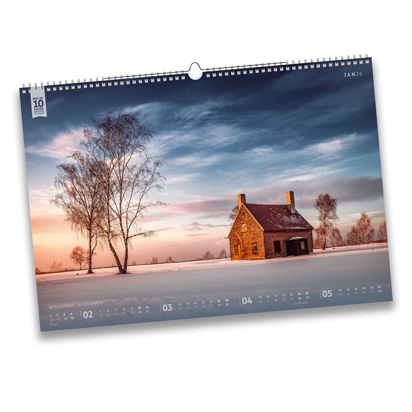 Kalenderblatt Januar 2026 des Bergstadtkalenders B3: Winteraufnahme der Bergschmiede Alte Elisabeth in Freiberg bei Sonnenuntergang, umgeben von verschneiten Feldern und Birken.