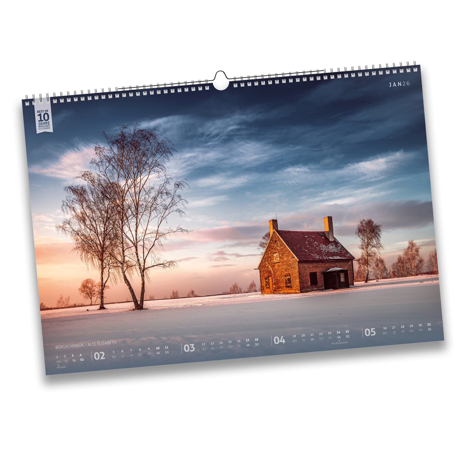 Kalenderblatt Januar 2026 des Bergstadtkalenders B3: Winteraufnahme der Bergschmiede Alte Elisabeth in Freiberg bei Sonnenuntergang, umgeben von verschneiten Feldern und Birken.