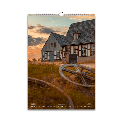 August-Motiv des Bergstadtkalenders 2026 im DIN-A3-Hochformat: die Alte Elisabeth in Freiberg bei Sonnenuntergang, mit Schwarzenberggebläse und Betstube und alten Seilscheiben im Vordergrund.