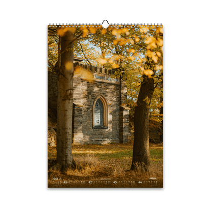 Oktober-Motiv des Bergstadtkalenders 2026 im DIN-A3-Hochformat: das historische Grabstätte Herders Ruh in Freiberg, umgeben von goldenem Herbstlaub und warmem Sonnenlicht zwischen den Bäumen.