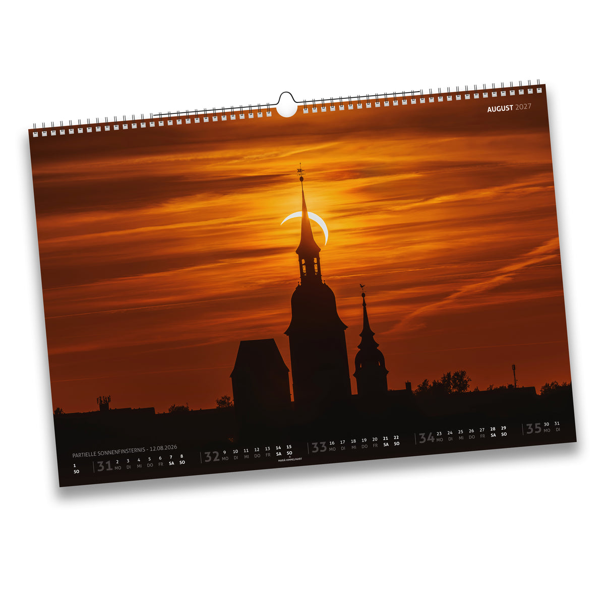 Kalenderblatt August 2027: Partielle Sonnenfinsternis am 12.08.2026 hinter den Türmen einer Freiberger Kirche im Abendrot.