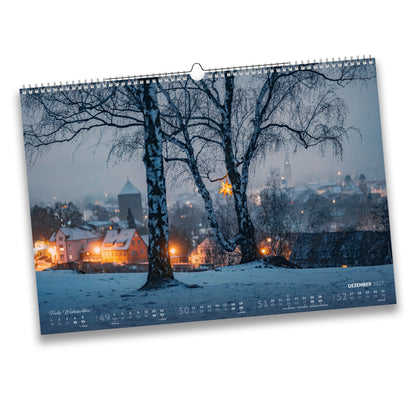 Kalenderblatt Dezember 2027: Winterlicher Blick über Freiberg zwischen Birkenstämmen, mit Weihnachtsstern und schneebedeckten Dächern – Frohe Weihnachten!