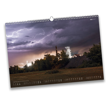 Kalenderblatt Juli 2027: Gewitter mit Blitzen über der Reichen Zeche in Freiberg, dramatische violette Wolkenstimmung.