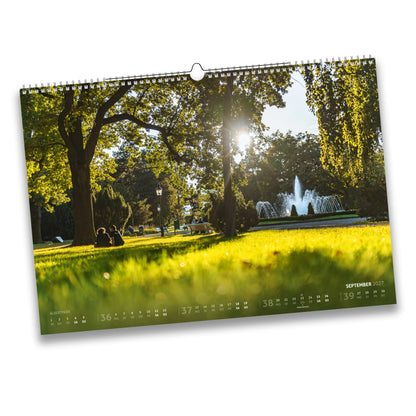 Kalenderblatt September 2027: Sonniger Spätsommertag im Albertpark Freiberg mit Springbrunnen und Besuchern im Gras.