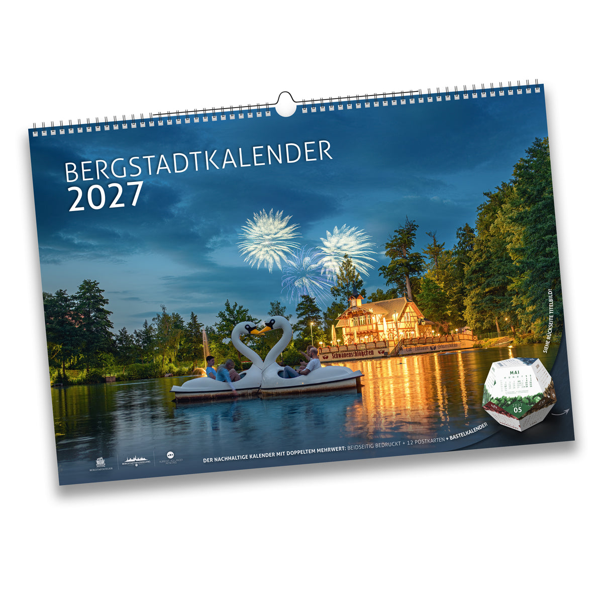 Titelblatt des Bergstadtkalenders 2027 im Format DIN B3: Schwanenschlösschen am Kreuzteich in Freiberg bei Dämmerung mit Feuerwerk zum Bergstadtfest, im Vordergrund ein Tretboot in Schwanenform.