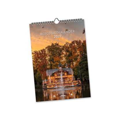 Titelblatt des Bergstadtkalenders 2027 im DIN A4 Hochformat mit dem Schwanenschlösschen in Freiberg vor herbstlichen Bäumen und seiner Spiegelung im Wasser.