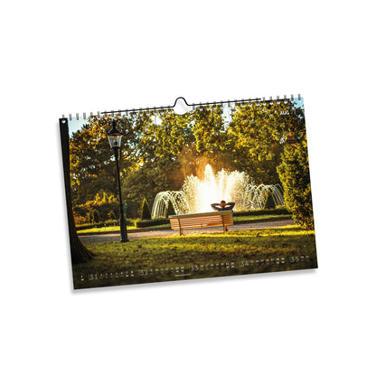 August 2027: Springbrunnen im Albertpark Freiberg zwischen Bäumen im goldenen Sonnenlicht.