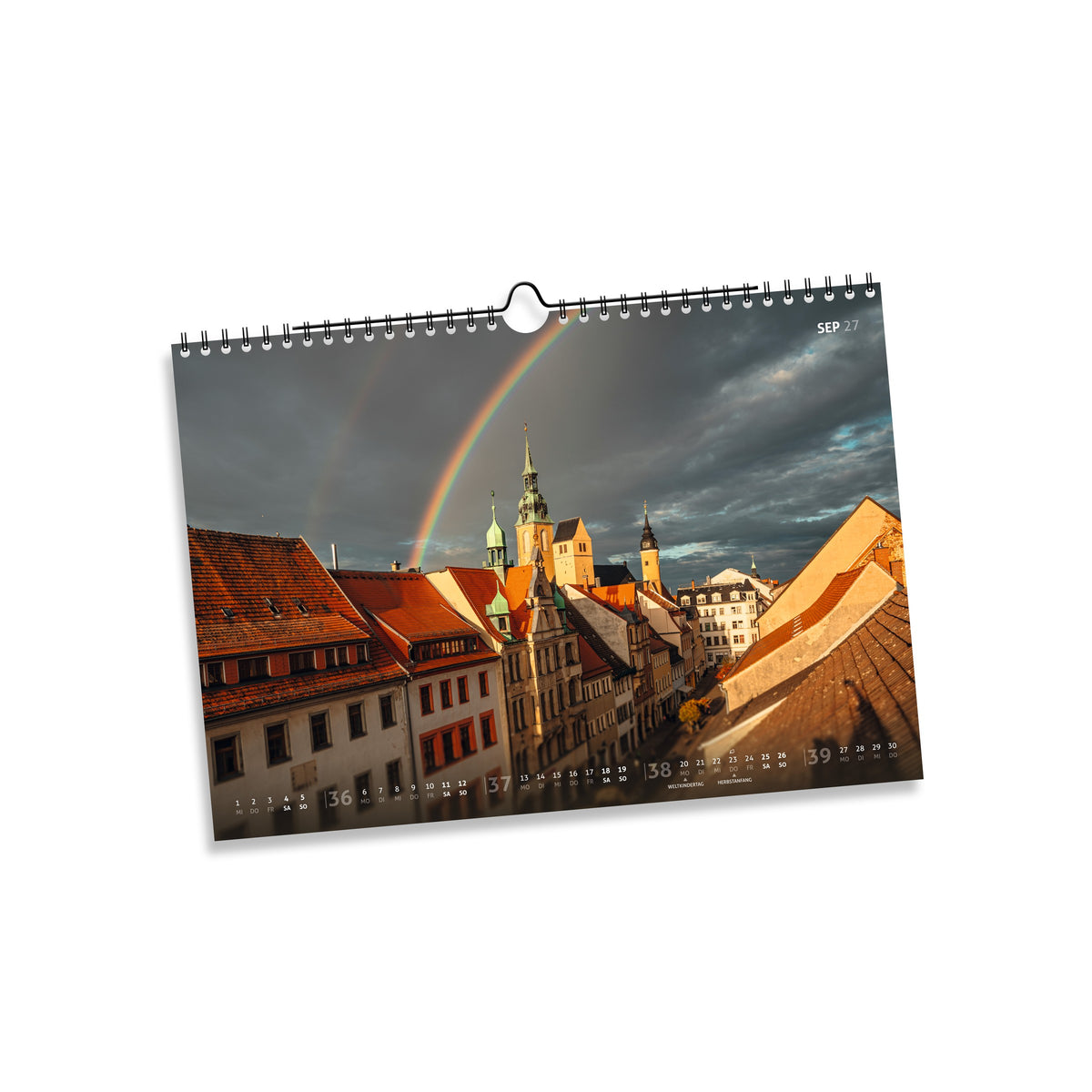 September 2027: Regenbogen über der Petrikirche und den roten Dächern der Freiberger Altstadt unter dunklen Wolken.