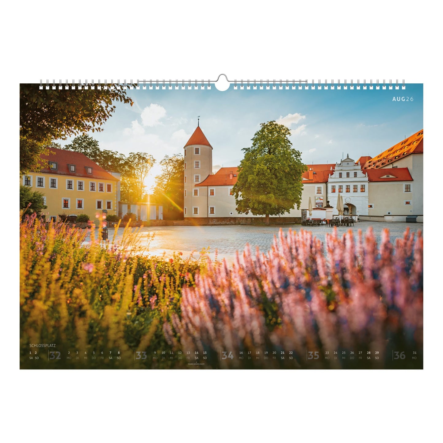Der Schlossplatz in Freiberg mit Schloss Freudenstein und blühenden Lavendelbeeten bei tiefstehender Sonne – ein Sinnbild für Sommer und Heimat.