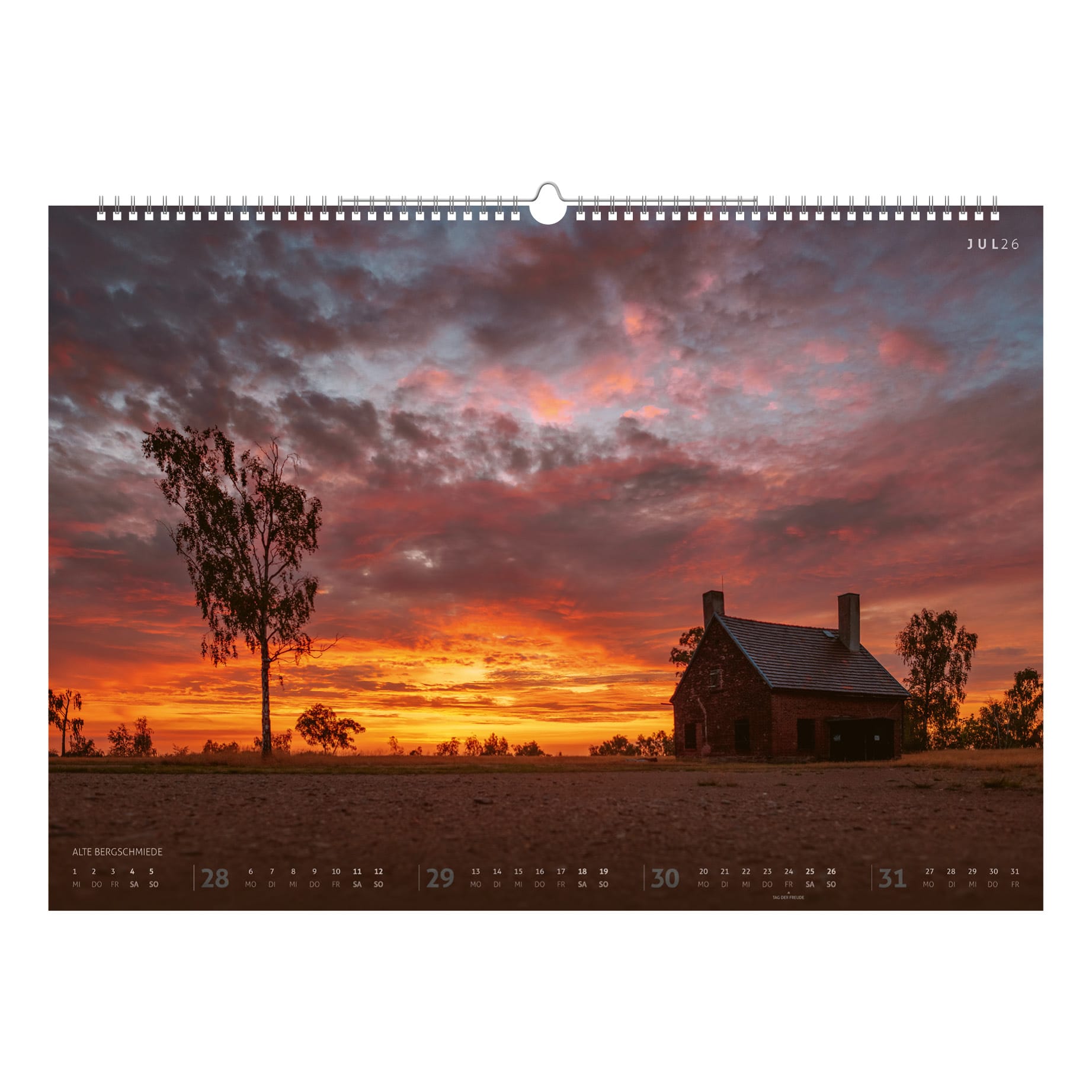 Die Alte Bergschmiede bei Freiberg im spektakulären Abendrot, eingerahmt von Silhouetten einsamer Bäume – ein Sommermotiv mit intensiver Lichtstimmung.