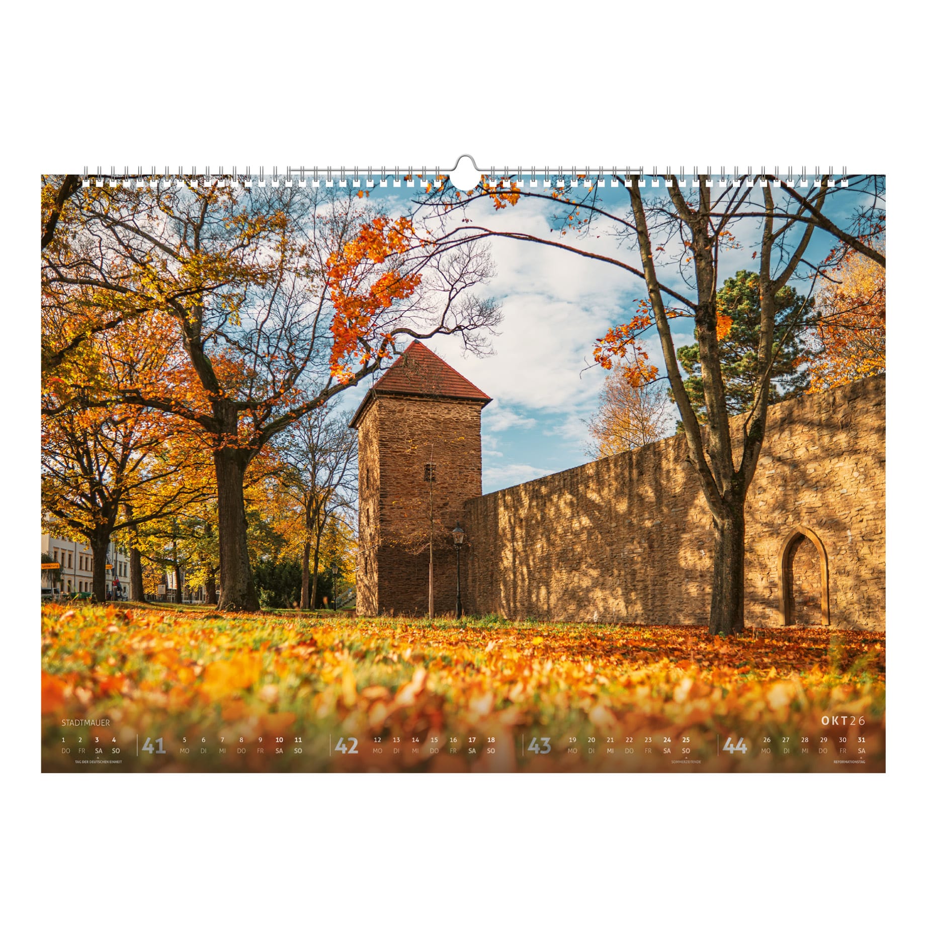 Herbstliche Szene an der Freiberger Stadtmauer mit Gelber Löwe Turm und buntem Laub, historischen Mauern und Türmen – Kalenderbild aus dem Bergstadtkalender 2026.