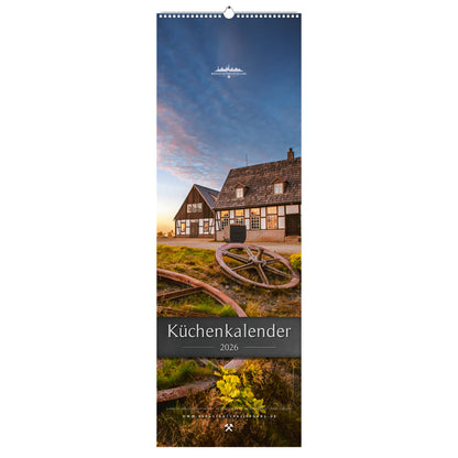 Titelmotiv des Küchenkalenders 2026 im schmalen Hochformat mit der Alten Elisabeth in Freiberg bei Sonnenuntergang, im Vordergrund historische Seilscheiben und warme Abendstimmung.