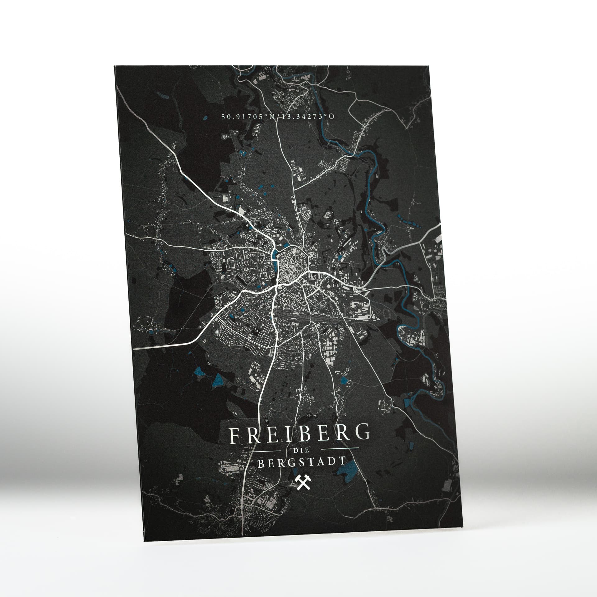 „Wandbild im DIN-A3-Format mit Stadtkarte von Freiberg auf silber gebürstetem Alu-Dibond. Das edle Butlerfinish spiegelt das Licht je nach Blickwinkel und verleiht dem Motiv der Silberstadt eine dynamische, metallische Anmutung. Erhältlich in verschiedenen Größen.“